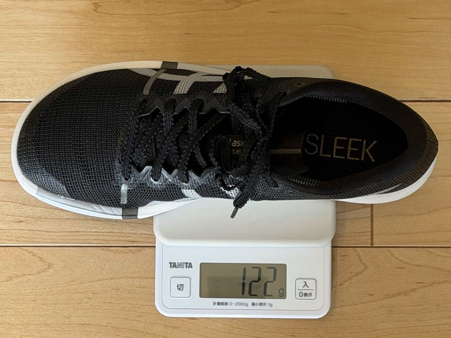 METASLEEK 26.5cmの右足を家庭用の電子はかりで測定し122gと表示されている写真
